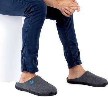 Model wearing the two-tone dark grey and blue slippers