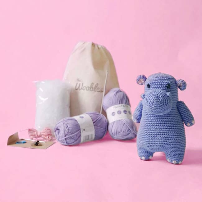 crochet hippo doll in front of full kit and packaging 