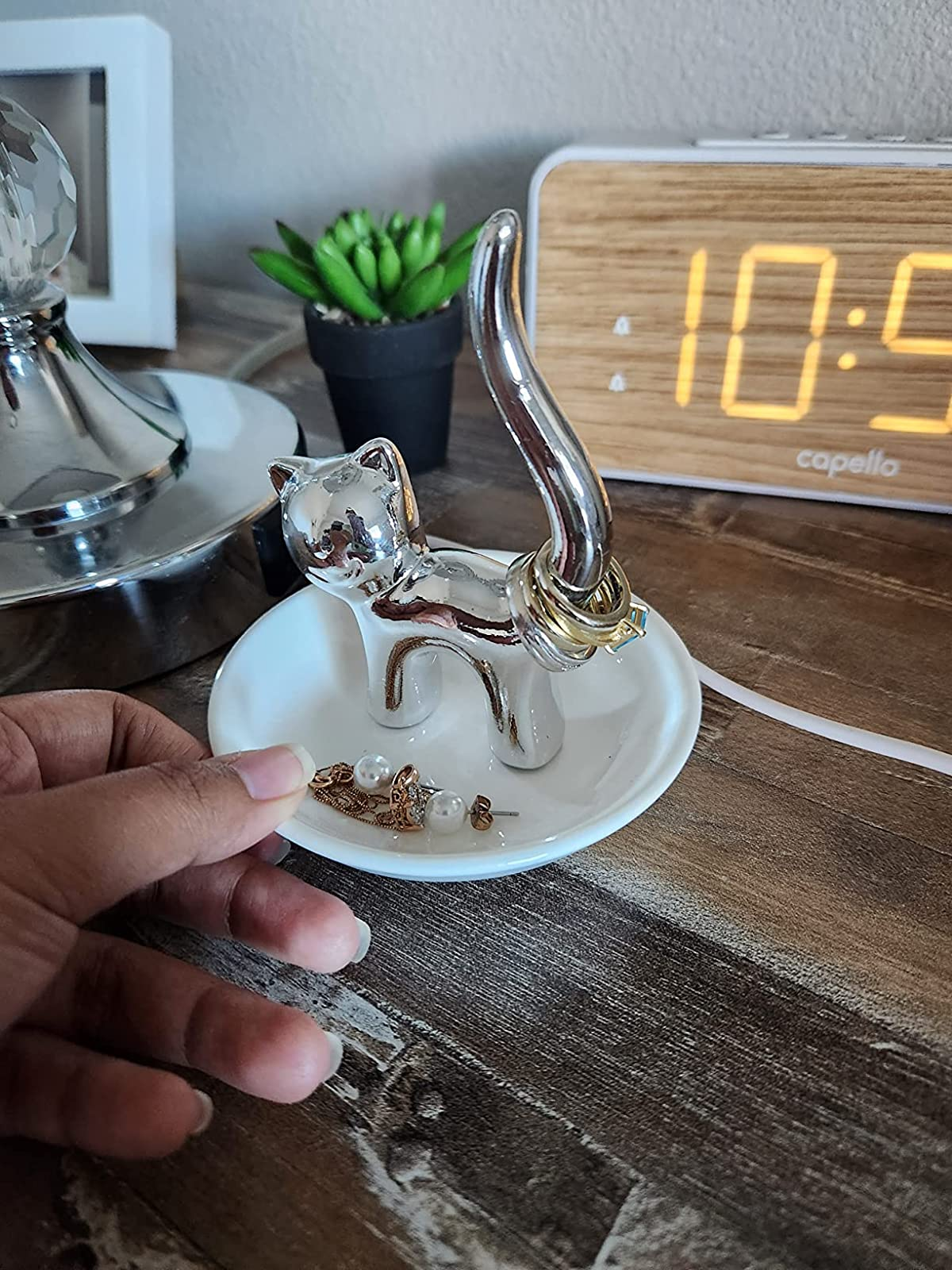 reviewer's hand holding the cat trinket dish