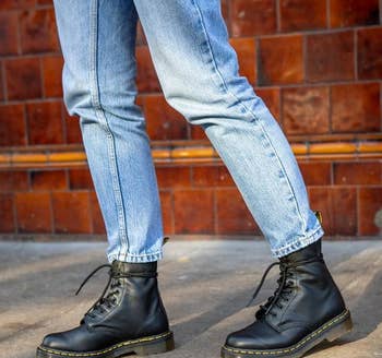 model wearing black lace up Dr. Martens boots with blue jeans
