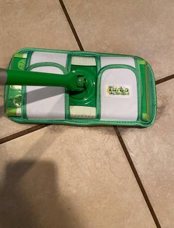 reviewer showing top of the reusable mop pad attcahed to a Swiffer Sweeper