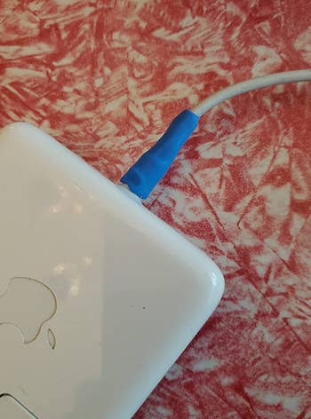 a reviewer photo of blue molded glue on a mac laptop charging cord 