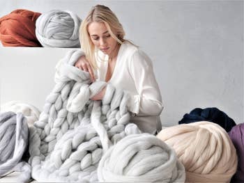 woman knitting huge blanket with arms, surrounded by big balls of yarn