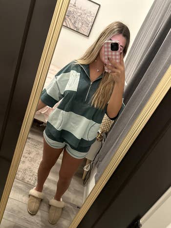 Person takes a reflector selfie wearing a casual striped zip-up outfit and fluffy slippers, lasting successful a chamber with neutral decor