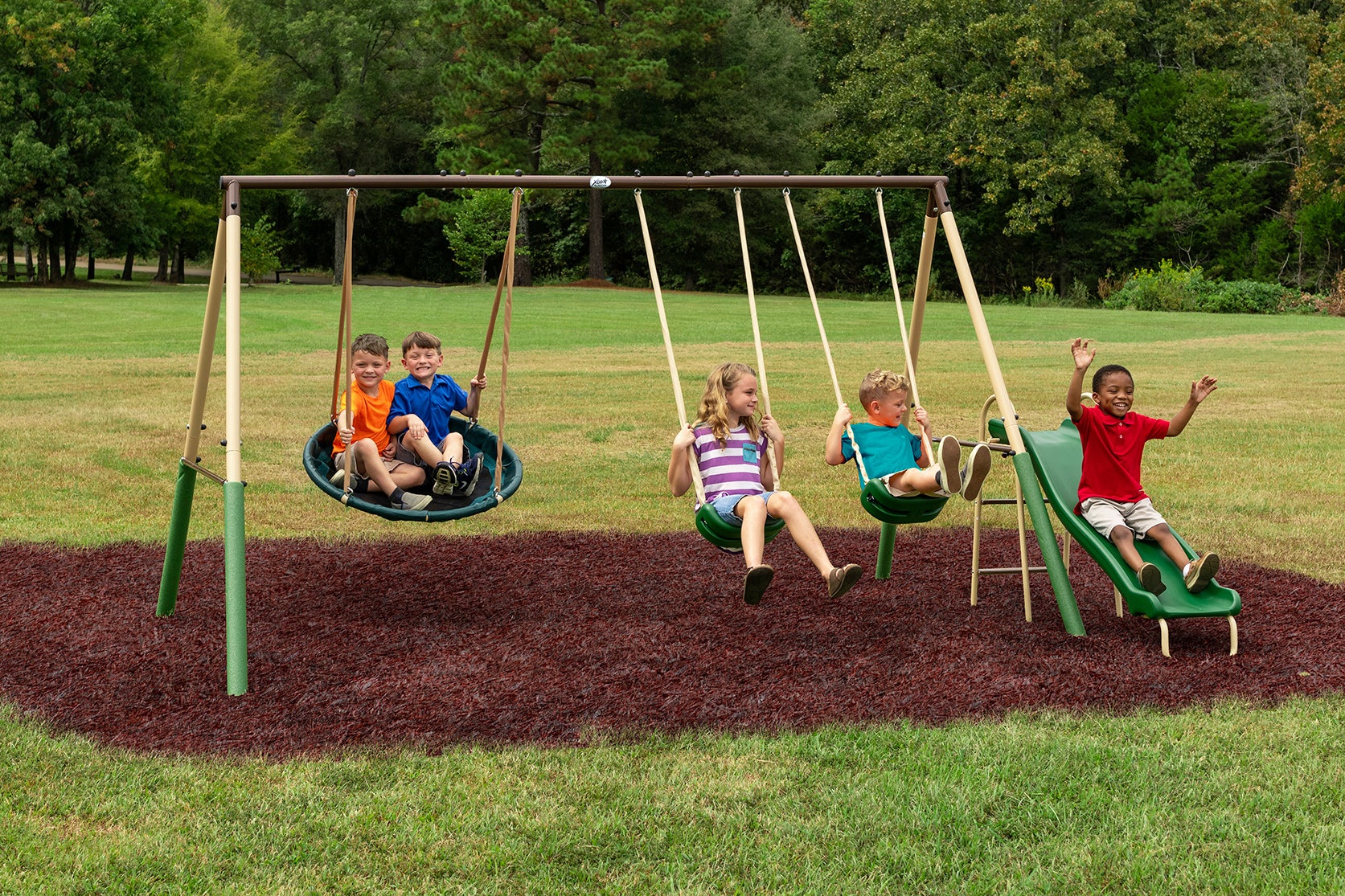 five kids playing on the swing set which includes two swings, a disc swing, and a slide