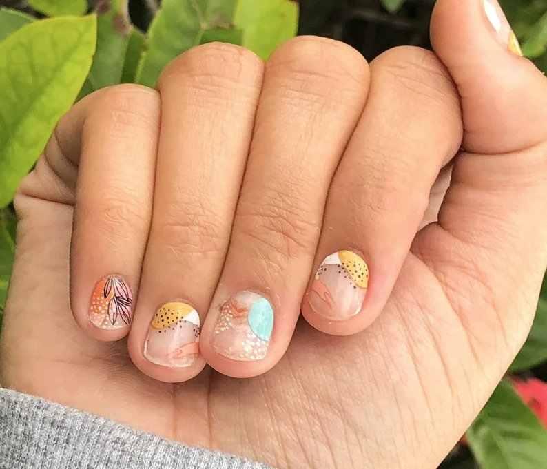 a model with the floral nail wraps applied to their nails 