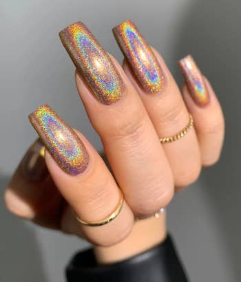 model holding their hand at a different angle to show the holographic nail polish 
