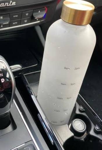 water bottle in a car cup holder twisted to show time markings on it 