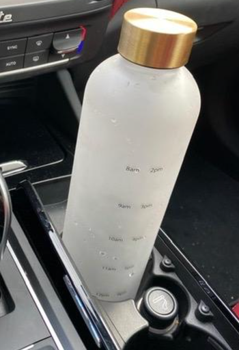 water bottle in a car cup holder twisted to show time markings on it 