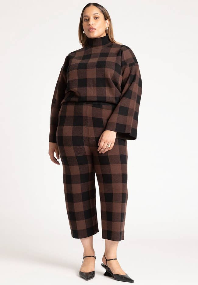 model wearing brown and black checkered sweater pants and mock neck sweater