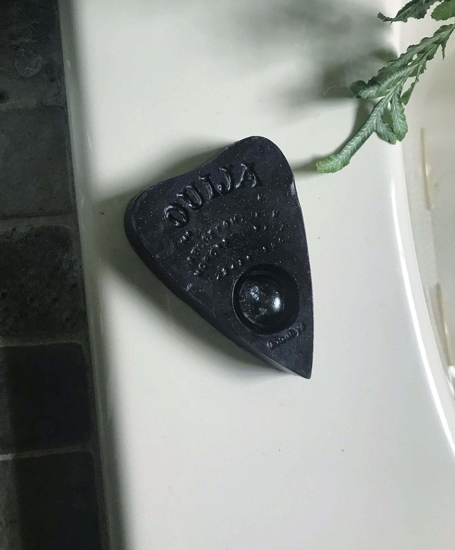 dark ouija planchette bar soap on lip of bath tub