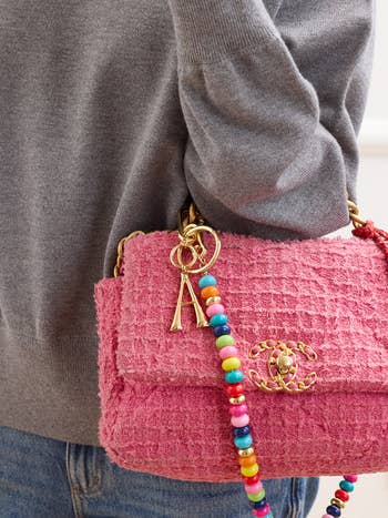 gold A charm attached to strap of a Chanel bag