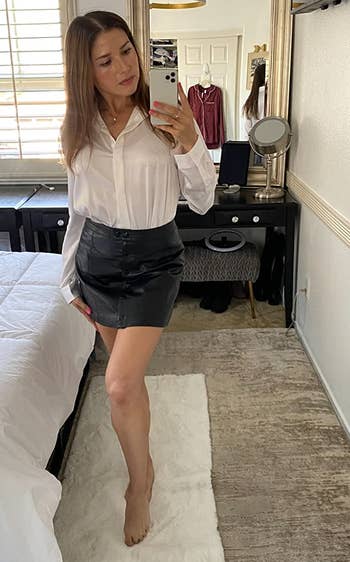 reviewer wearing the blouse tucked into a leather skirt
