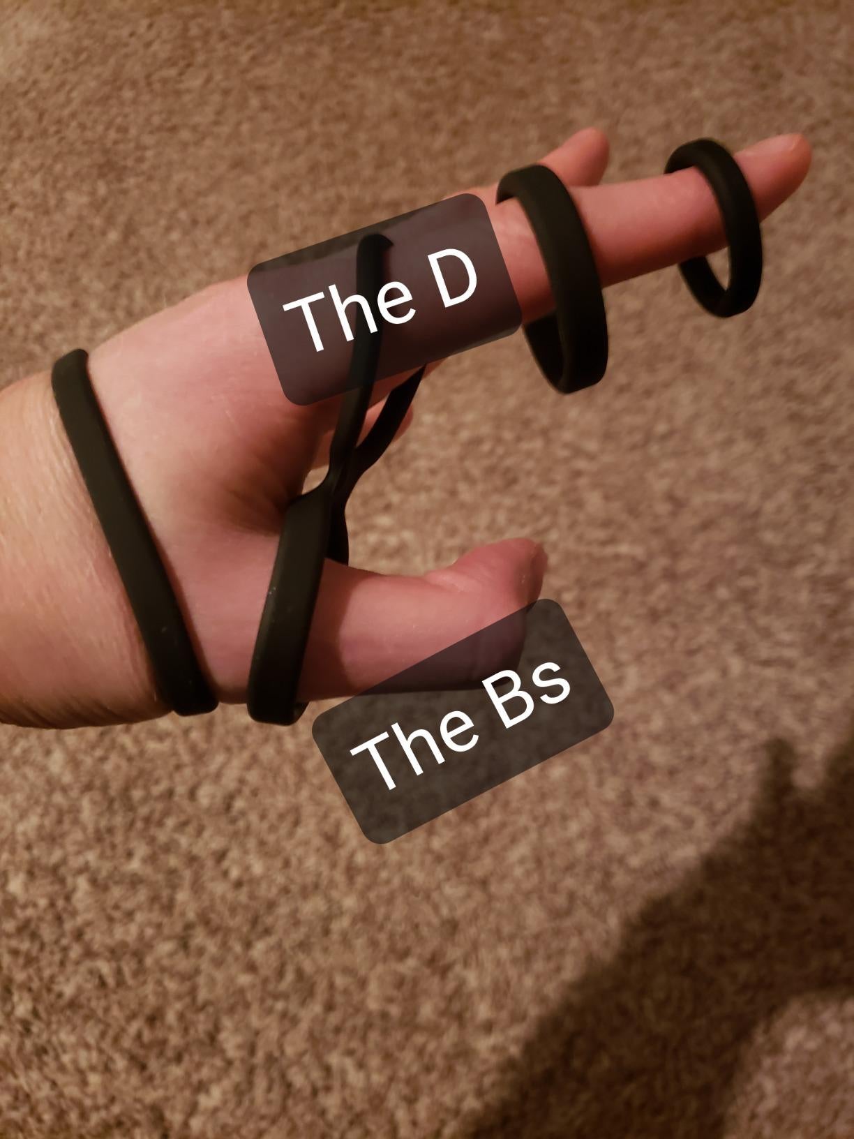 Model stretching silicone cock rings around hand in demonstration