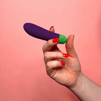 Model holding purple eggplant vibrator