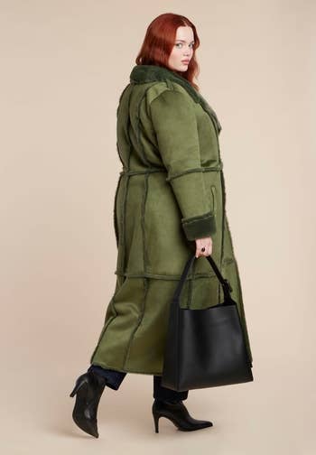 Person successful  long, textured overgarment  holding a achromatic  tote bag, wearing pointed boots. Fashion focused, showcasing a wintertime  buying  style