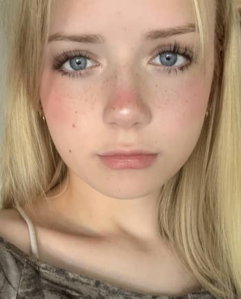 Person with airy hairsbreadth and freckles, wearing a brownish top, looking straight astatine the camera