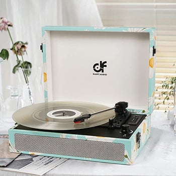 Daisy patterned blue and white portable turntable with silver stylus on top of white table