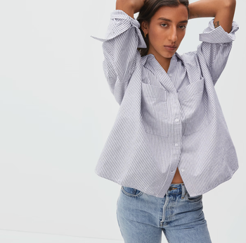 Model in oversized fitting blue and white stripe collared button up shirt