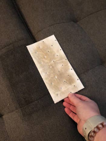 a reviewer holding the pad which is covered in some sort of stain