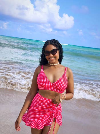 Person astatine the formation wearing a stylish polka-dot swimsuit, smiling and posing successful beforehand of the water waves