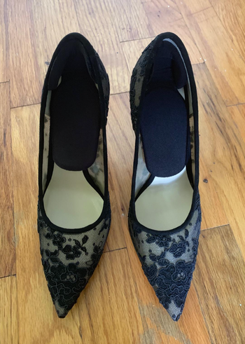 A reviewer's heels with inserts attached to the bottom of the heel 