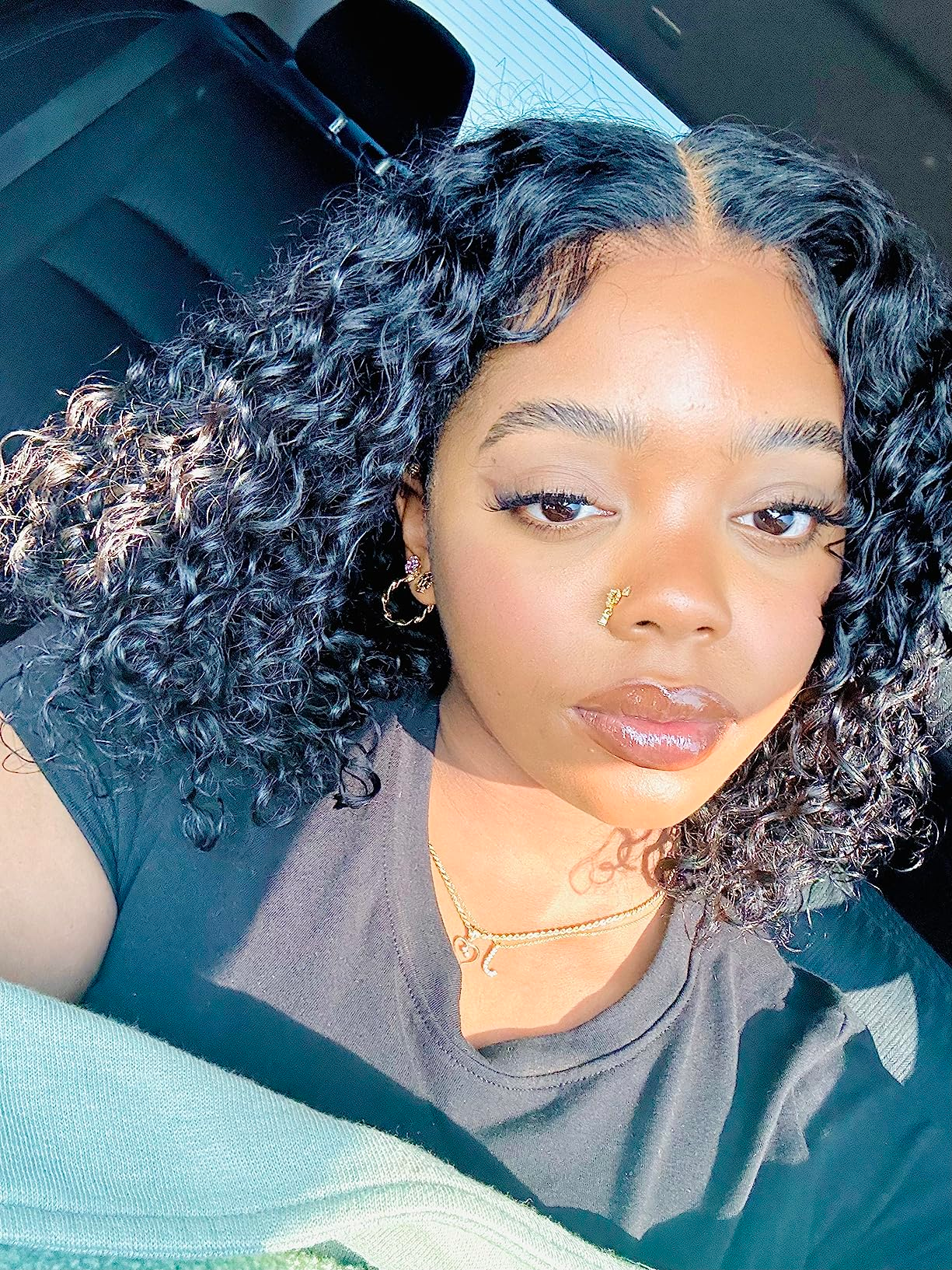 Person with curly hairsbreadth  and a chemoreceptor  ringing  takes a selfie successful  a car, wearing a casual garment  and necklace