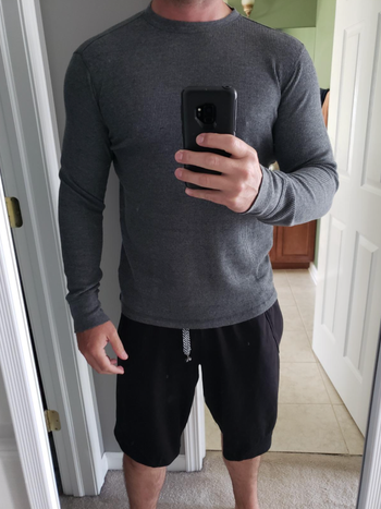 different reviewer taking a selfie while wearing the waffle knit in grey