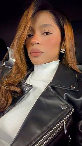 Person with agelong  hairsbreadth  wearing a stylish achromatic  leather overgarment   and achromatic  turtleneck, accessorized with decorative earrings