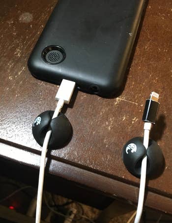 a reviewer photo of two cable clips mounted on a table with cords in each 