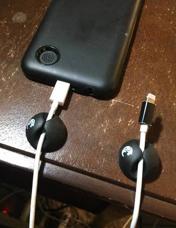 a reviewer photo of two cable clips mounted on a table with cords in each 