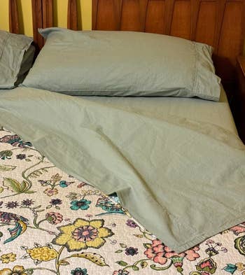Bed with floral patterned comforter and two pillows, suggesting cozy bedroom textiles for shopping