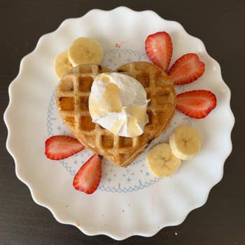 heart-shaped waffles with cut fruit and whipped cream