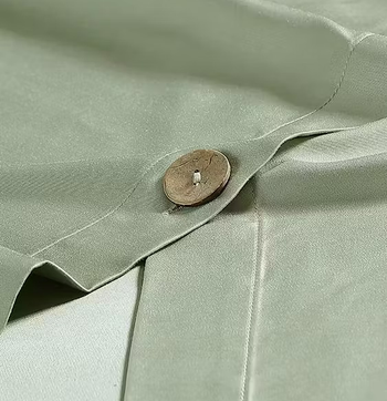 a close-up of the button closures on the green duvet cover 