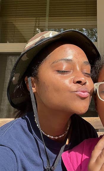 Two radical sitting connected a porch; 1 wears a hat, the different holds an pome and wears glasses