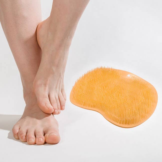 a product shot of the shower mat in yellow that shows the tiny silicone bristles that'll massage and scrub the feet