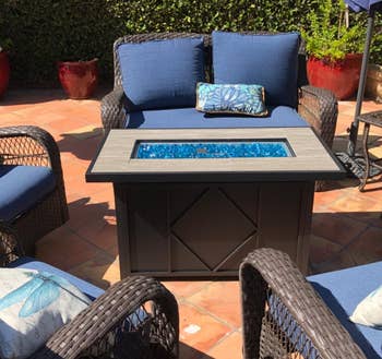 Reviewer image of the black fire pit next to blue chairs