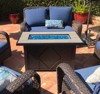 Reviewer image of the black fire pit next to blue chairs
