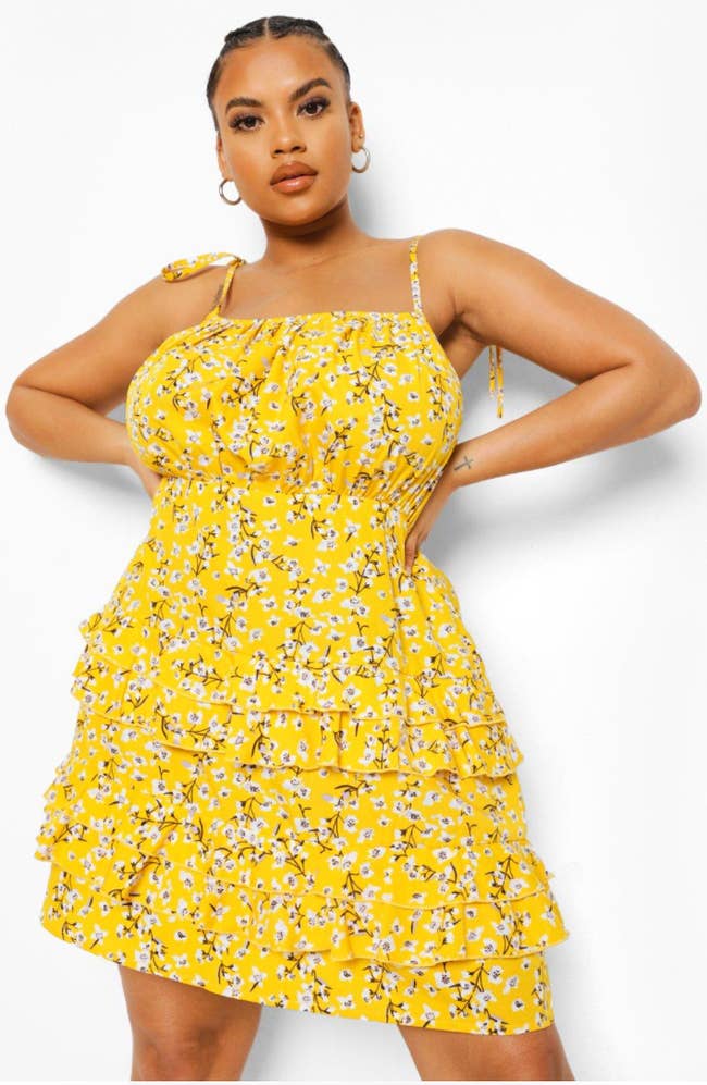 Model in a yellow strap tank tiered ruffled floral dress 
