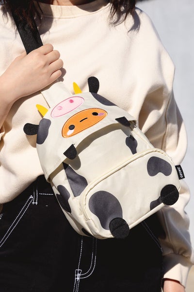 model wearing crossbody pack shaped like a potato in a cow costume