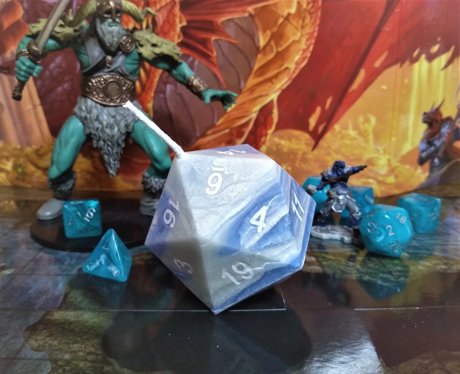 the d20 candle amongst real, small dice