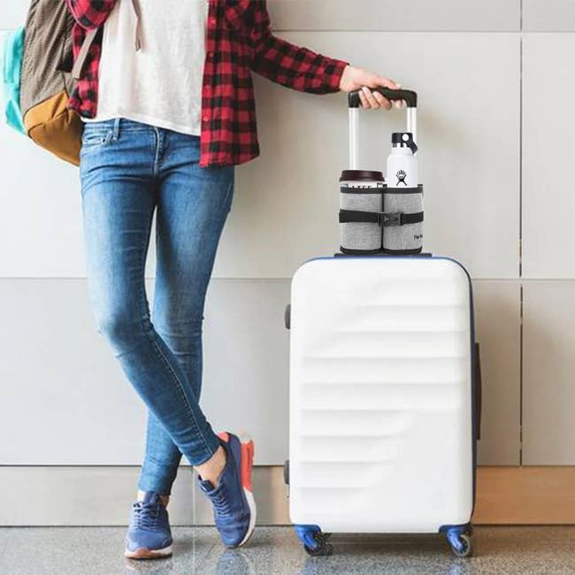 model holding suitcase handle that had the luggage cup holder strapped to it