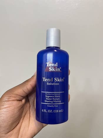 reviewer holding the tend bottle