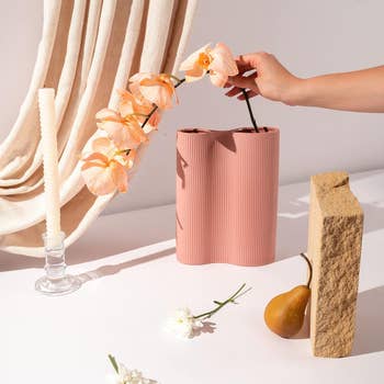 model placing flower in the pink vase