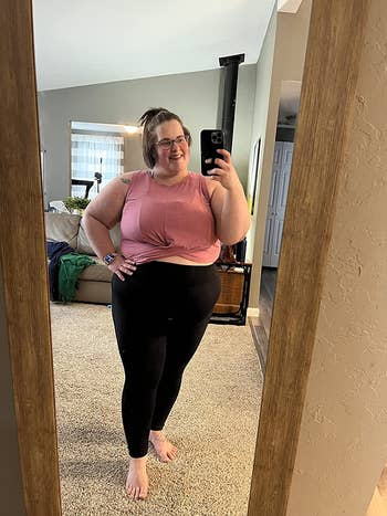 reviewer in dark pink twist-front crop top and black leggings