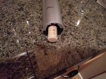 a reviewer's wine opener with a cork sticking out that has been removed
