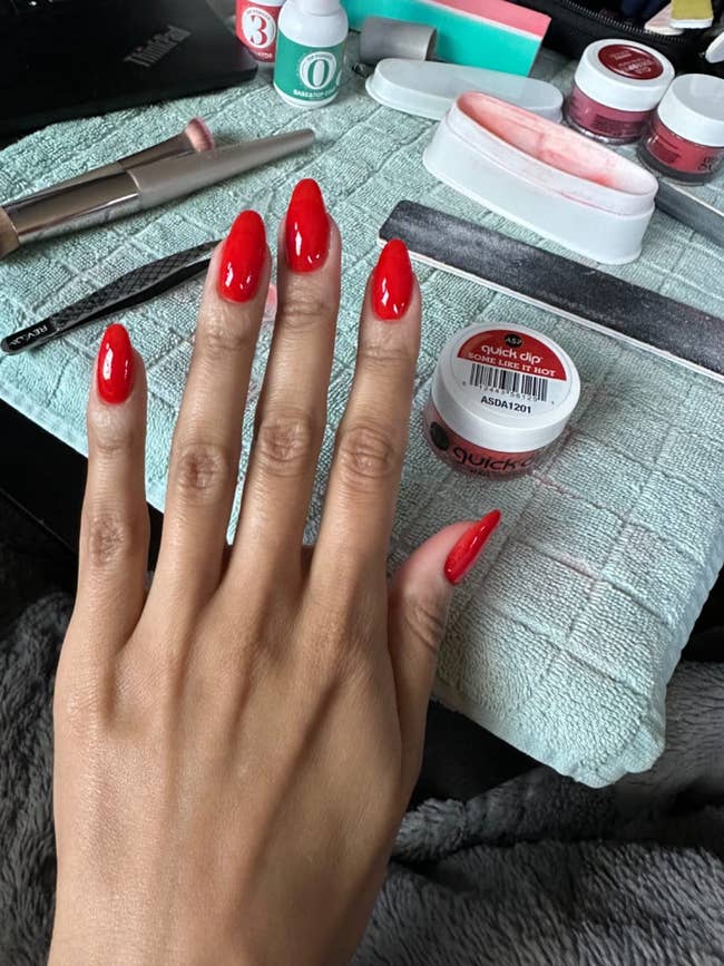 hand with red powder manicure