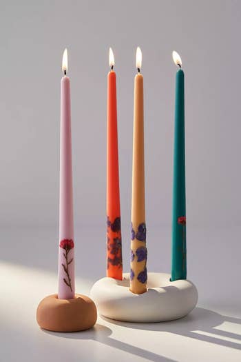 pink orange yellow and teal candles that are lit