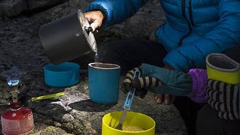 someone pouring water from the pot, in dark campsite