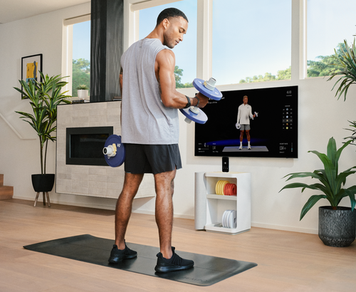 Model holding dumbells in front of Temp Move and TV 